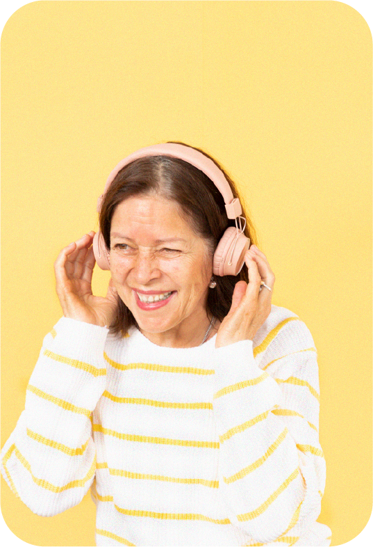 Mujer mayor sonriendo con audífonos